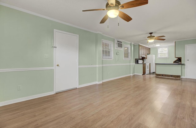 unfurnished living room with an AC wall unit, light hardwood / wood-style flooring, ceiling fan, and crown molding