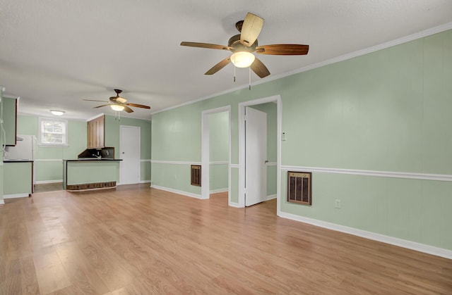 unfurnished living room with light hardwood / wood-style floors, ceiling fan, and ornamental molding