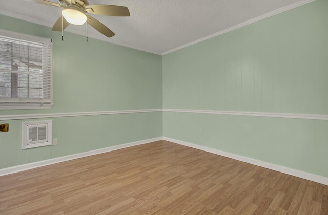 spare room with a textured ceiling, light hardwood / wood-style floors, ceiling fan, and ornamental molding