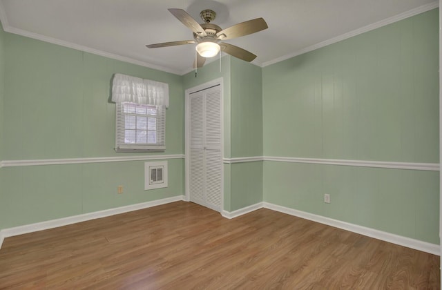 spare room featuring light wood-type flooring, ceiling fan, and crown molding