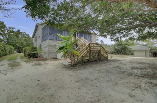 view of front of home featuring a sunroom and a shed