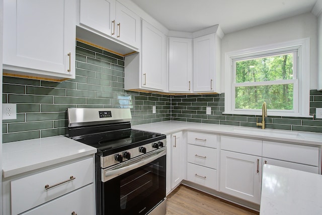 3231 Stonehaven Dr, North Charleston, SC 29420 - kitchen with stainless steel electric stove, a sink, light countertops, decorative backsplash, and white cabinetry