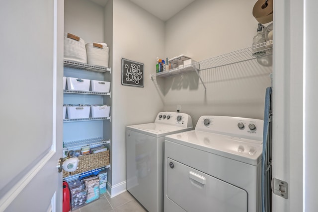 laundry area featuring washer and dryer, baseboards, laundry area, and light tile patterned floors