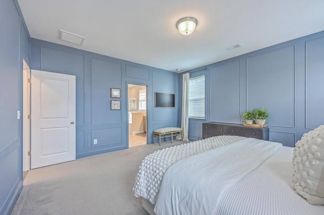 bedroom with a decorative wall, visible vents, and carpet