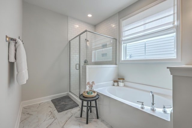 bathroom featuring baseboards, a garden tub, marble finish floor, and a shower stall