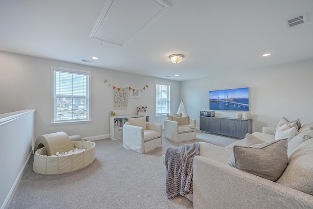 carpeted living area featuring recessed lighting, visible vents, baseboards, and attic access