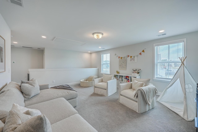 carpeted living area with attic access, recessed lighting, visible vents, and baseboards