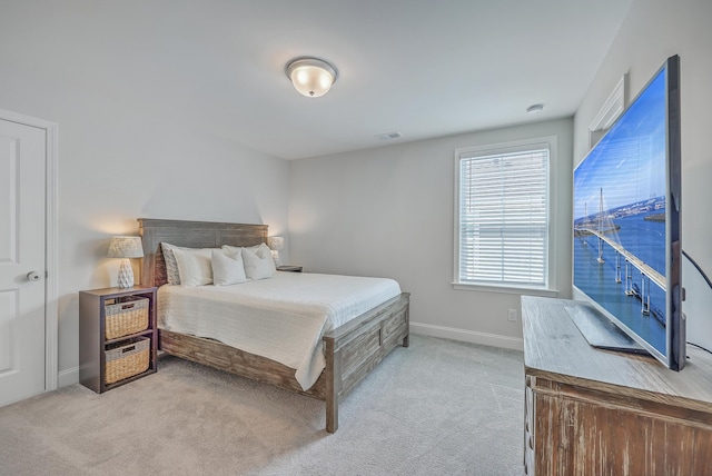 bedroom featuring visible vents, light carpet, and baseboards