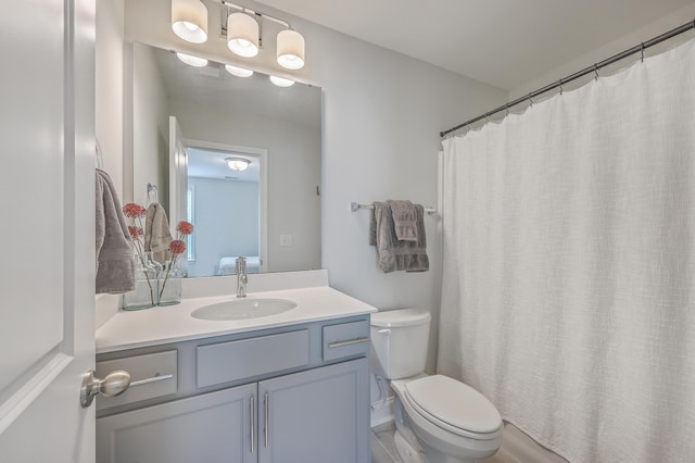 full bathroom featuring a shower with shower curtain, toilet, and vanity