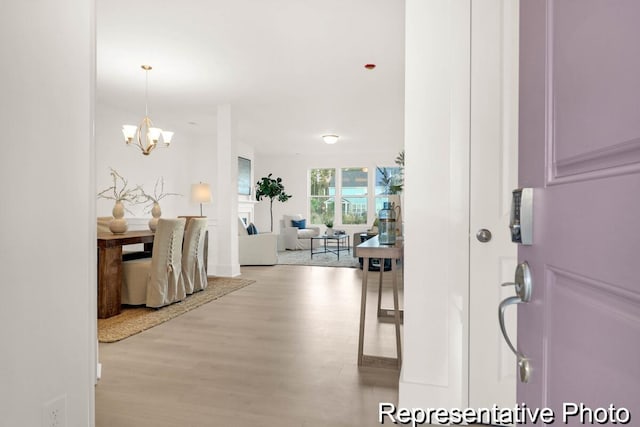 foyer entrance with a notable chandelier and light wood finished floors