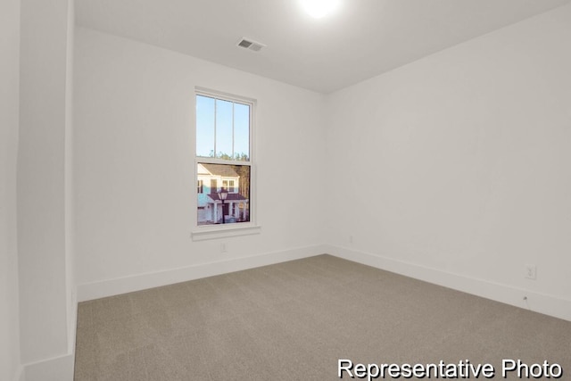 carpeted spare room with baseboards and visible vents