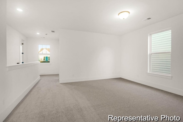 carpeted empty room featuring recessed lighting, visible vents, and baseboards