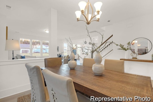 dining space with an inviting chandelier, stairway, and visible vents