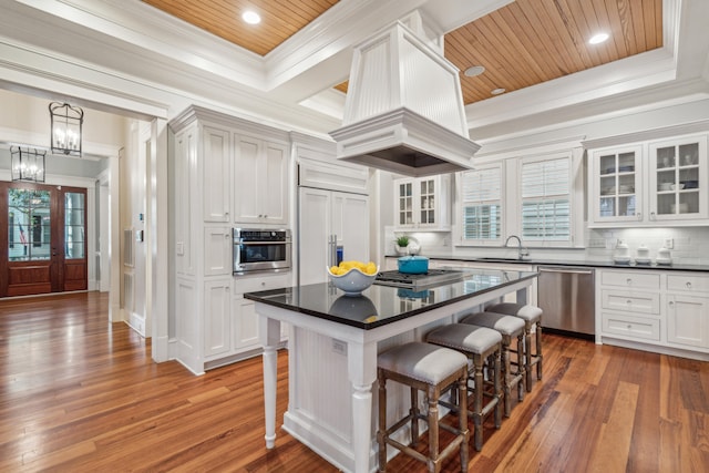 kitchen featuring a kitchen island, dark wood-type flooring, stainless steel appliances, a breakfast bar, and tasteful backsplash