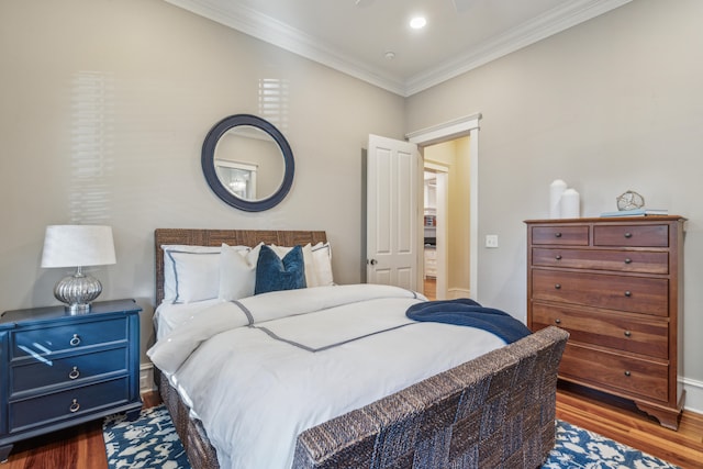 bedroom with ornamental molding and dark hardwood / wood-style floors