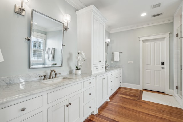 bathroom with vanity, crown molding, and wood-type flooring