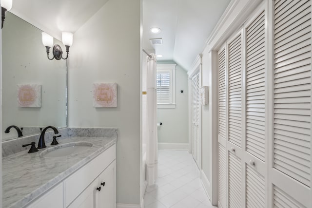 bathroom featuring vanity, tile patterned floors, and vaulted ceiling