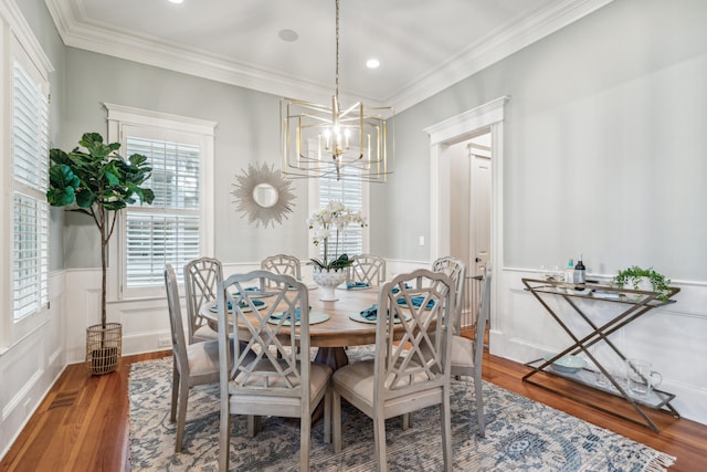 dining room with an inviting chandelier, crown molding, and hardwood / wood-style flooring