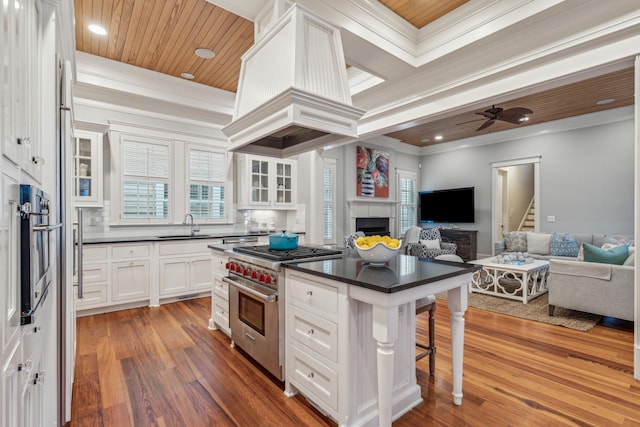 kitchen featuring a kitchen island, dark hardwood / wood-style floors, stainless steel appliances, a breakfast bar, and white cabinets