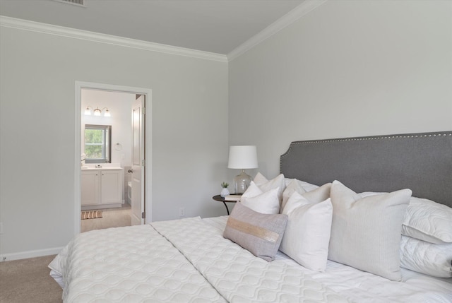 bedroom with carpet, crown molding, baseboards, and ensuite bathroom