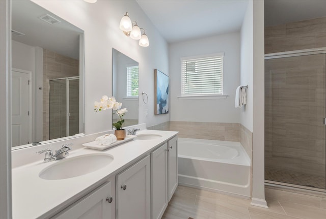 bathroom featuring a bath, a sink, visible vents, and a stall shower