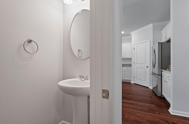 bathroom with wood finished floors and ornamental molding