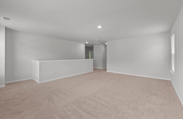empty room featuring light colored carpet, baseboards, visible vents, and recessed lighting