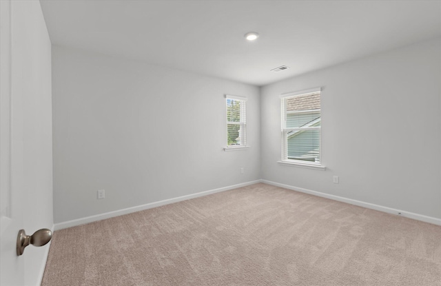 carpeted empty room featuring baseboards and visible vents