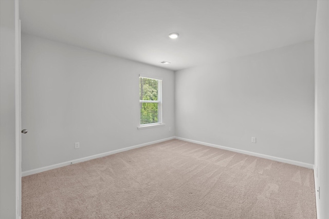 carpeted spare room featuring baseboards