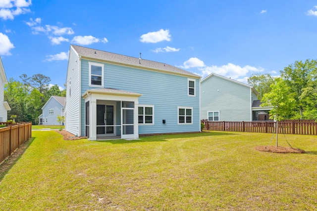 rear view of property with fence, a yard, and a sunroom