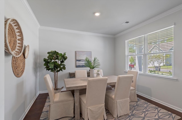 dining area featuring wood finished floors, visible vents, baseboards, and ornamental molding