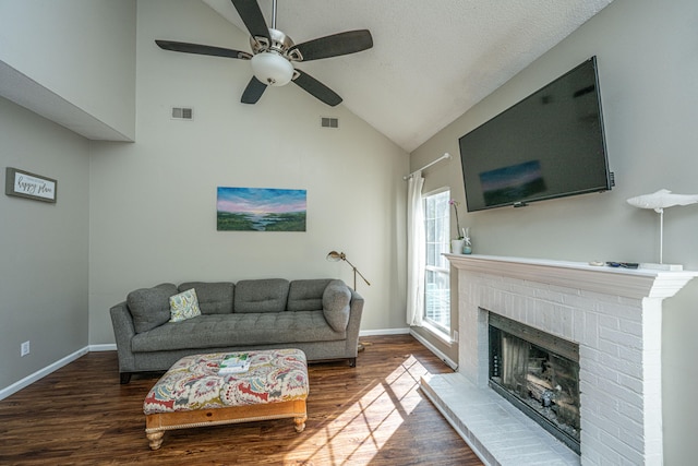 living room featuring a brick fireplace, a textured ceiling, ceiling fan, hardwood / wood-style flooring, and high vaulted ceiling