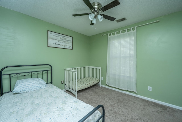 bedroom with carpet flooring, ceiling fan, and a textured ceiling