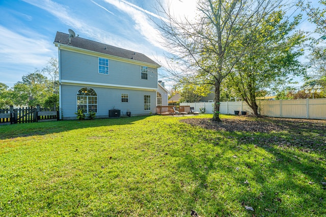 back of property with central AC and a yard