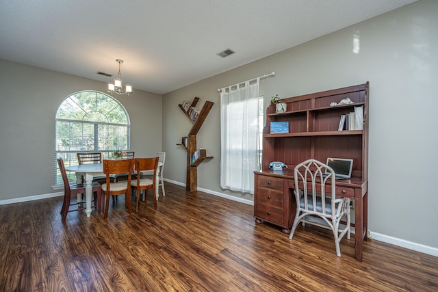 dining room featuring a textured ceiling, a chandelier, and dark hardwood / wood-style floors