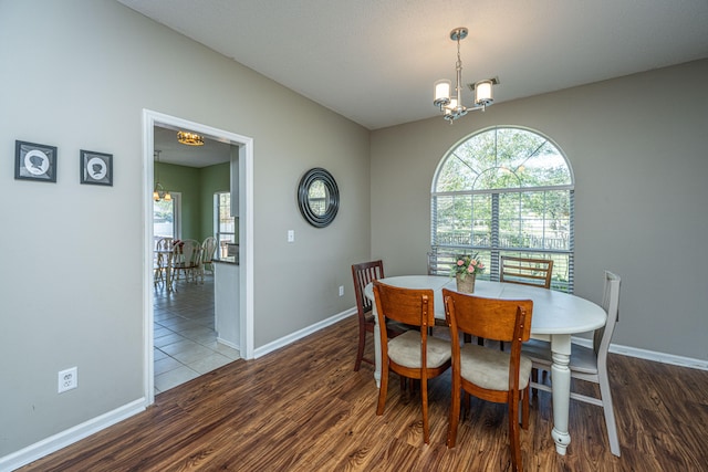 dining room with dark hardwood / wood-style floors and a notable chandelier