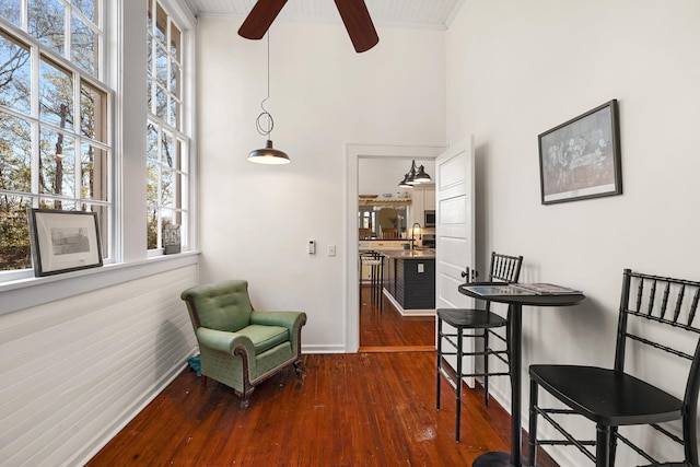 dining area with ceiling fan, a towering ceiling, sink, and dark hardwood / wood-style flooring