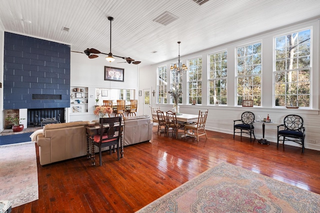 living room with dark wood-type flooring, ceiling fan with notable chandelier, wood ceiling, and a fireplace