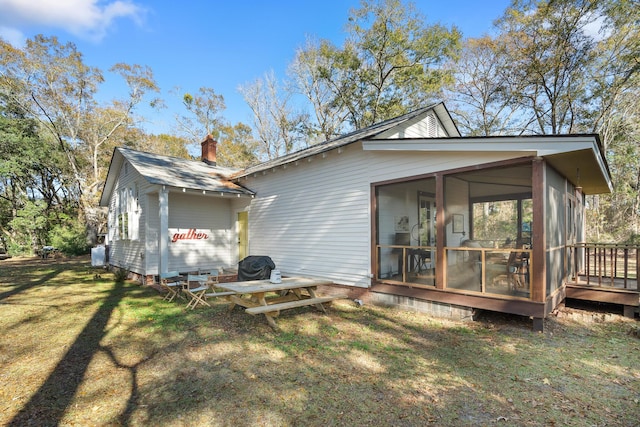 back of house with a yard and a sunroom