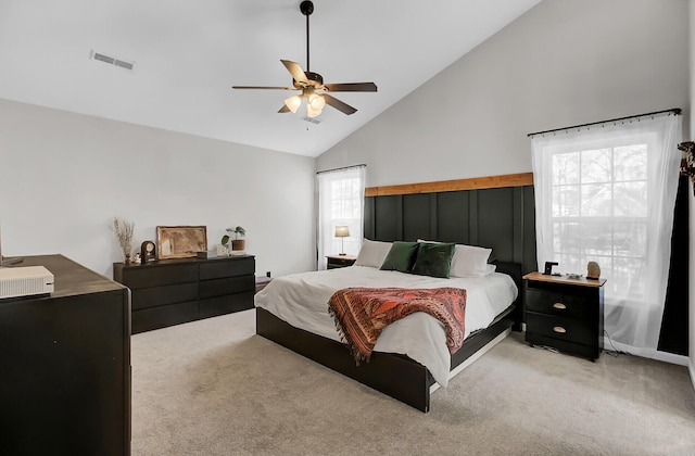 bedroom with high vaulted ceiling, light carpet, visible vents, and a ceiling fan