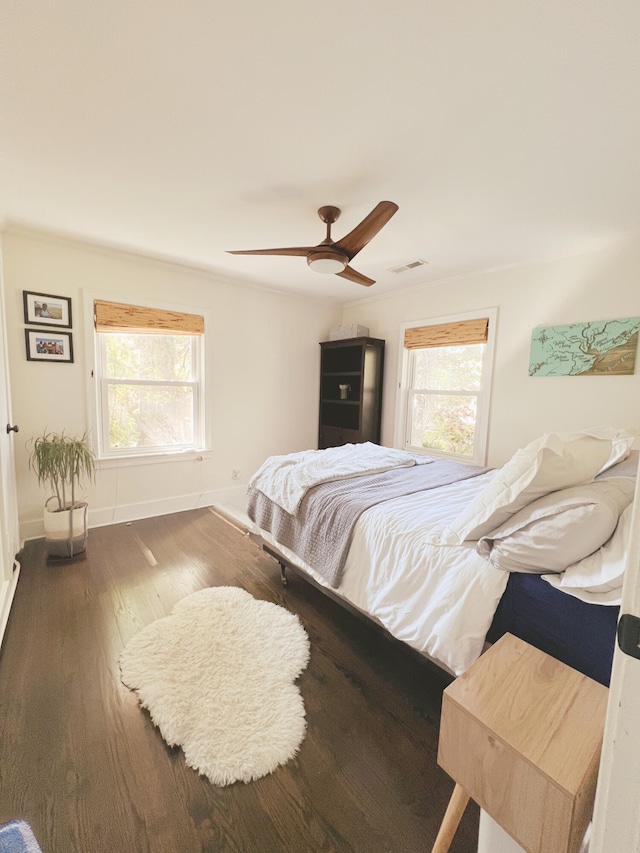 bedroom with multiple windows, ceiling fan, and hardwood / wood-style floors