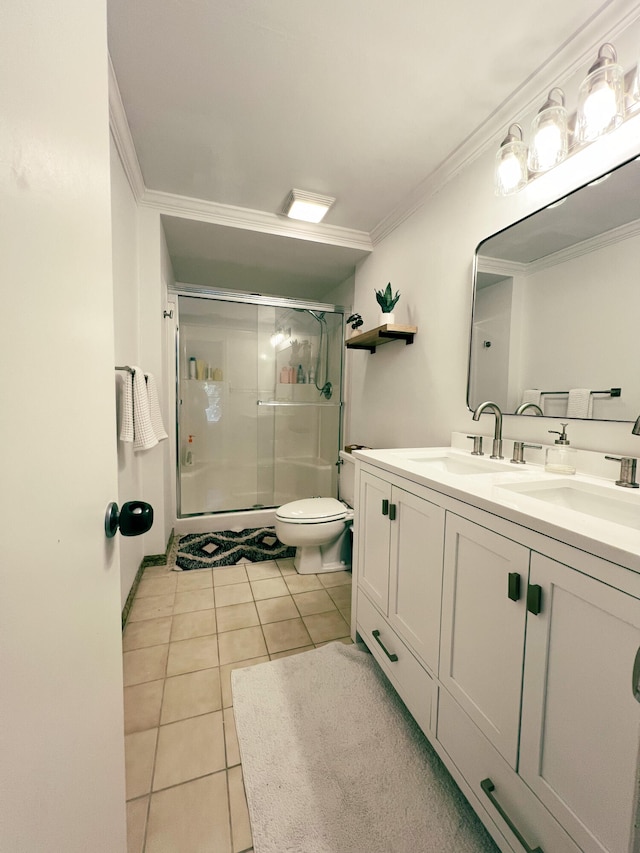 bathroom featuring vanity, a shower with door, tile patterned floors, toilet, and ornamental molding