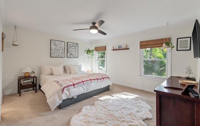 bedroom with light colored carpet, ceiling fan, and crown molding