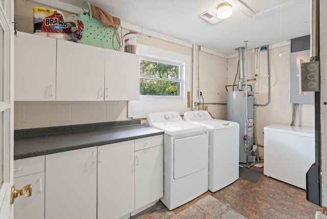 washroom with water heater, washer and clothes dryer, and cabinets