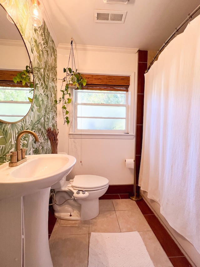 bathroom featuring tile patterned flooring, toilet, crown molding, and sink