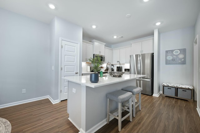 148 Omalley Dr, Summerville, SC 29483 - kitchen with light countertops, a center island with sink, dark wood-style floors, stainless steel appliances, and white cabinets