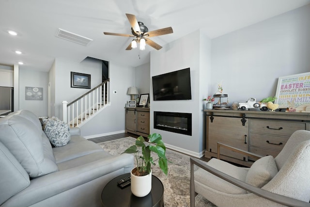 148 Omalley Dr, Summerville, SC 29483 - living room featuring visible vents, ceiling fan, wood finished floors, stairway, and a glass covered fireplace