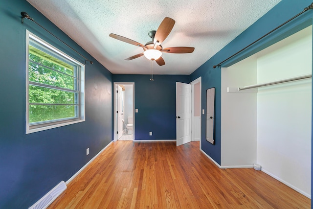 7 Plainfield Dr, Charleston, SC 29407 - unfurnished bedroom with a textured ceiling, wood finished floors, a closet, a ceiling fan, and ensuite bath