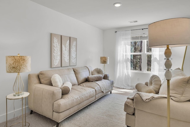 carpeted living area featuring visible vents and baseboards