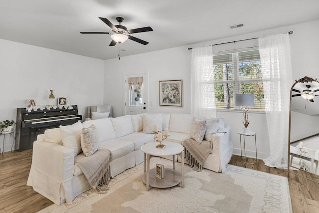 living area featuring ceiling fan, visible vents, and wood finished floors